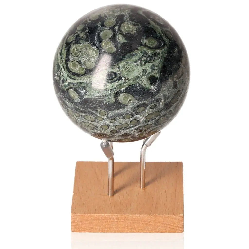 Kambaba Jasper Sphere on stand, known as Stone of Peace, promotes calmness and emotional stability with green and black patterns.