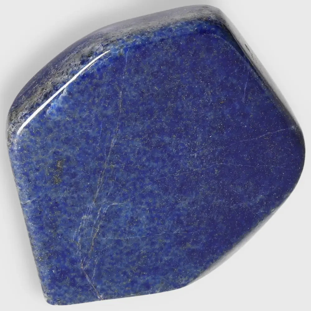 Lapis Lazuli obelisk with deep blue hues and golden pyrite flecks from Pakistan, symbolizing wisdom and enhancing energy.