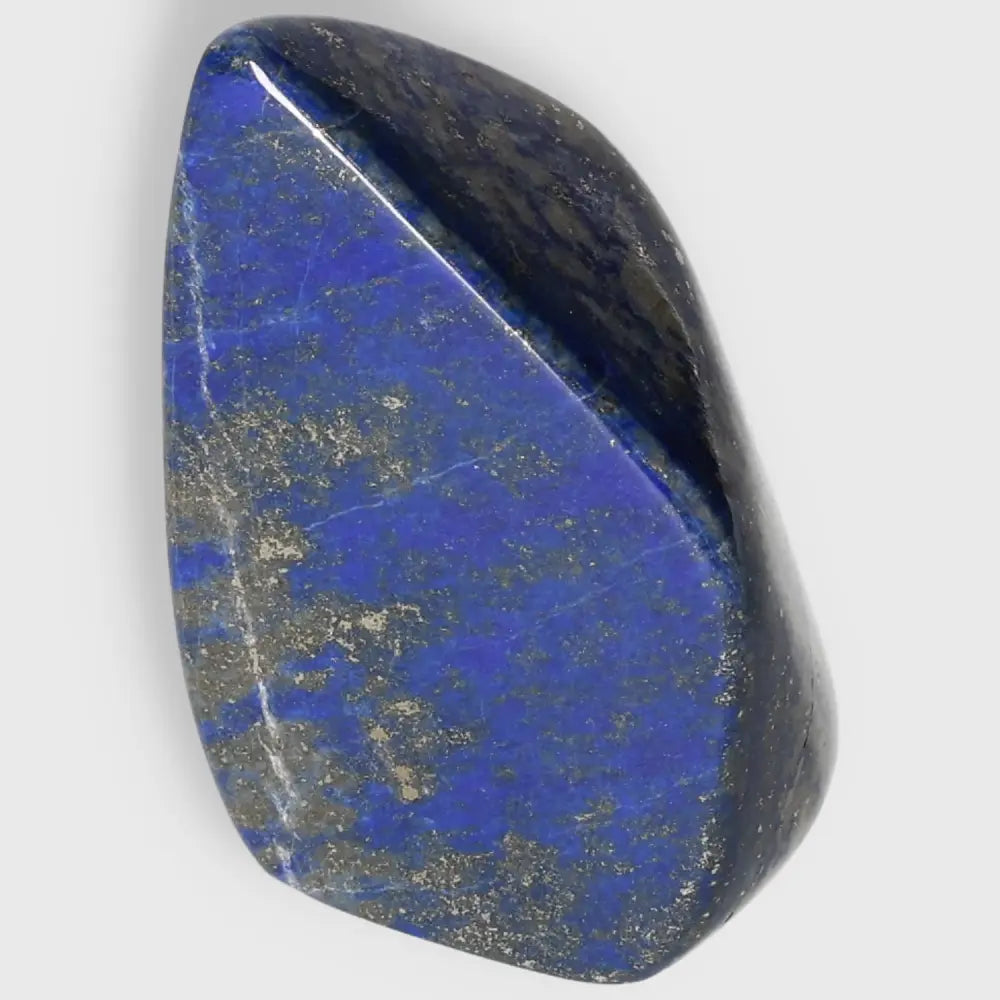 Lapis Lazuli obelisk with deep blue hues and golden pyrite flecks, a symbol of wisdom and focus, sourced from Pakistan.
