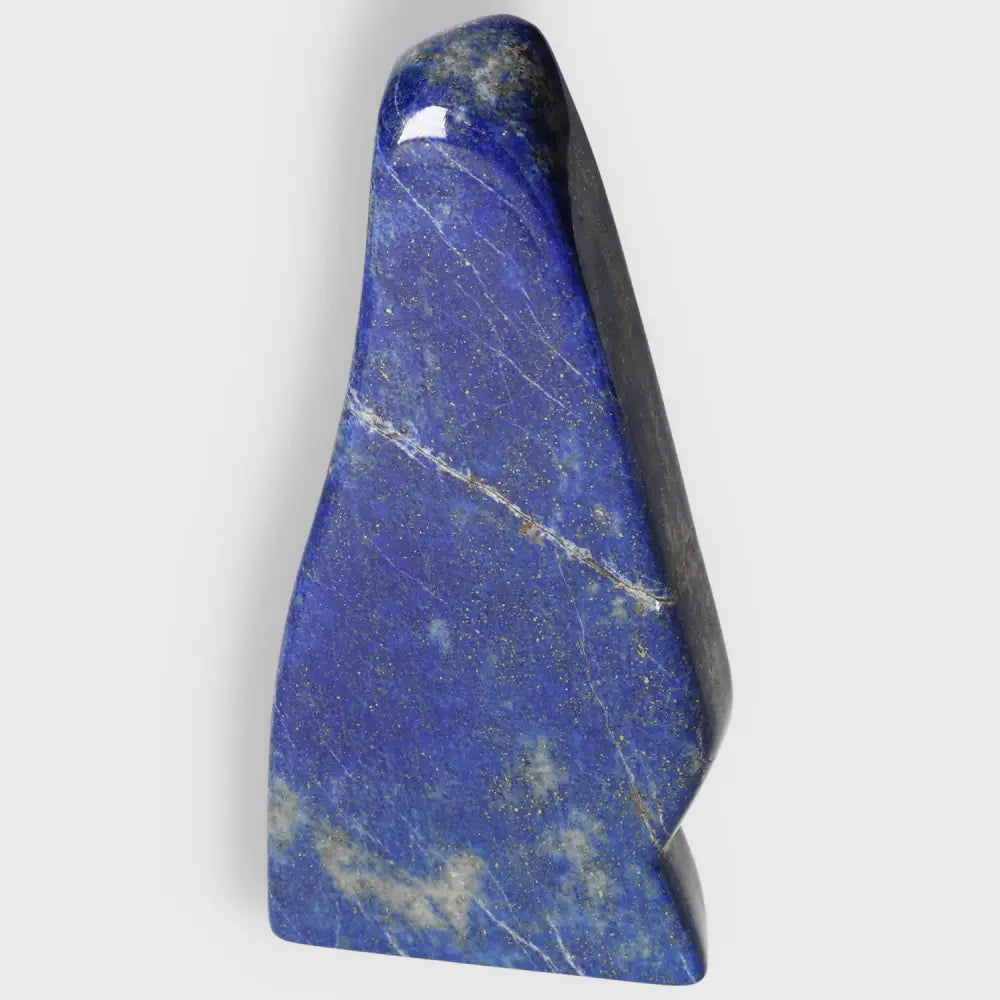 Lapis Lazuli Obelisk with deep blue hues and golden pyrite flecks, a symbol of wisdom and power, ideal for décor and energy enhancement.