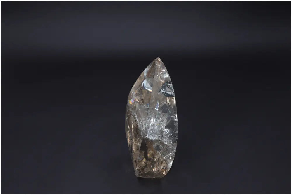 Large Lemurian Quartz Obelisk showcasing natural clarity and powerful healing properties on a dark background.