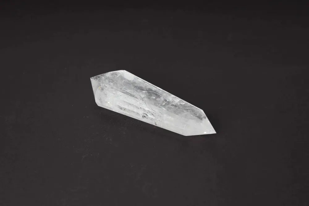 Lemurian Quartz Point with distinct horizontal striations on a dark background, showcasing ancient wisdom and spiritual energy.