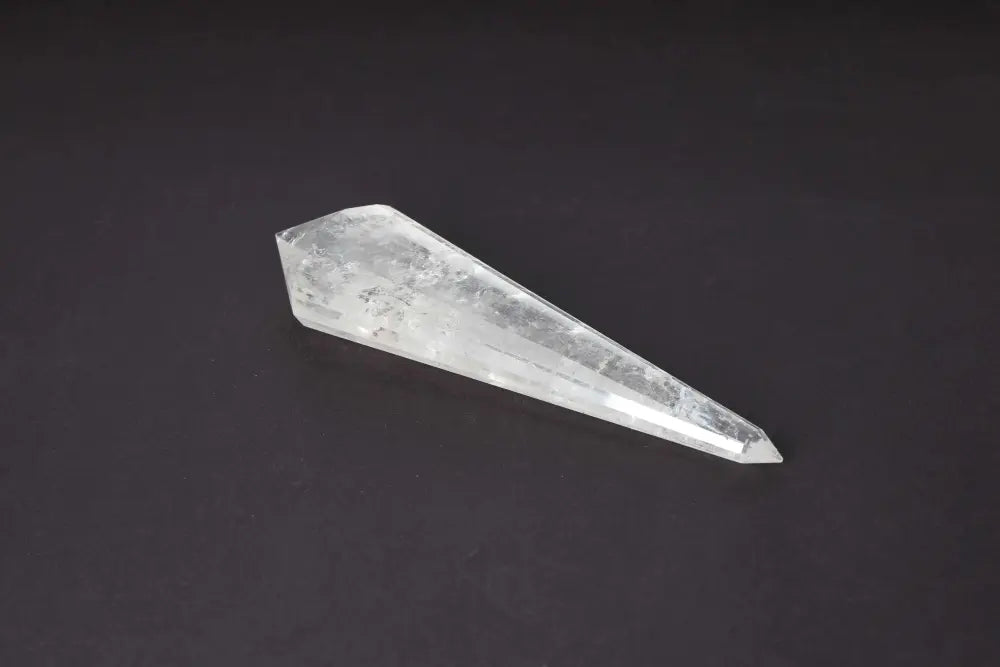 Lemurian Quartz Point crystal with ancient horizontal striations on a dark background, symbolizing ancient wisdom and spiritual harmony.