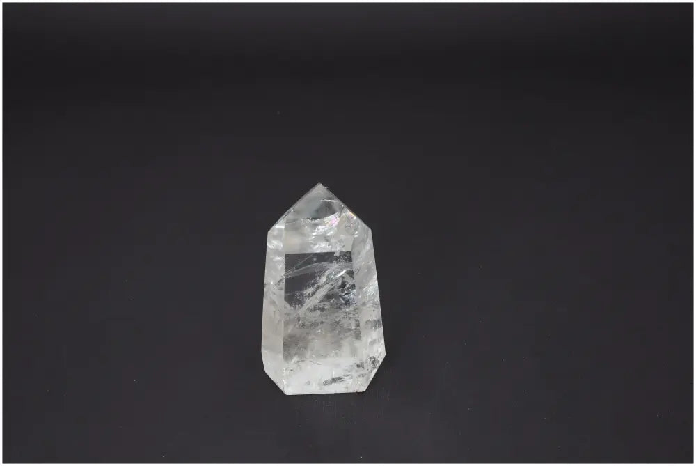 Lemurian Quartz Obelisk on black background, enhances body and soul energy, aligns chakras, with spiritual and zodiac connections.