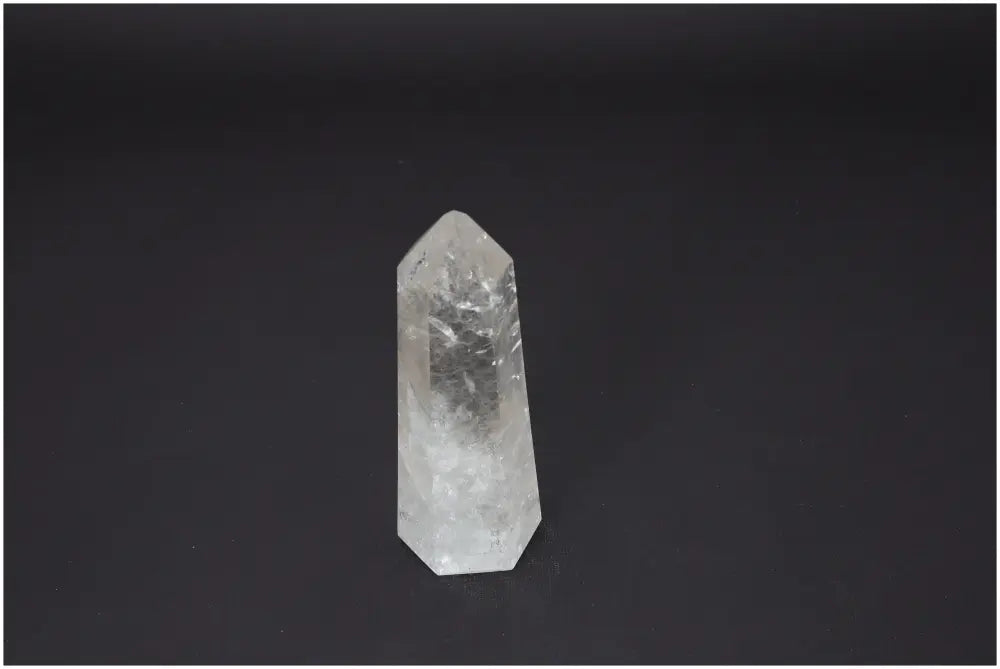 Clear Lemurian Quartz Obelisk on black background, highlighting its unique spiritual properties and chakra associations.