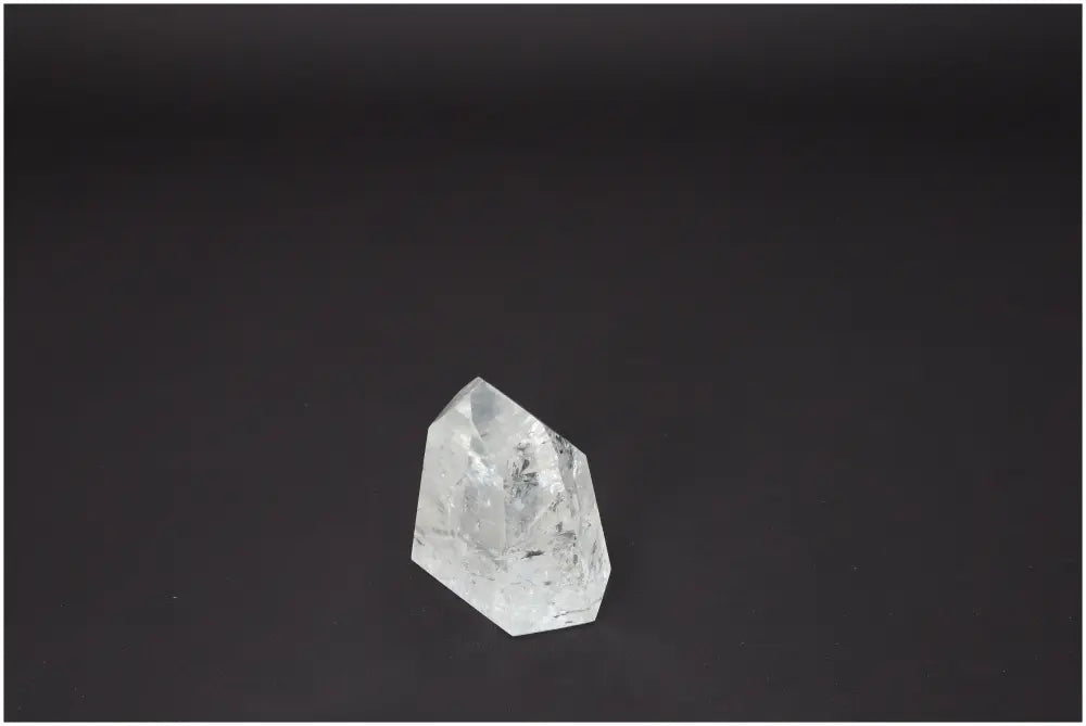 Lemurian Quartz Obelisk on dark background, showcasing its clear structure and unique energy properties for chakra alignment.