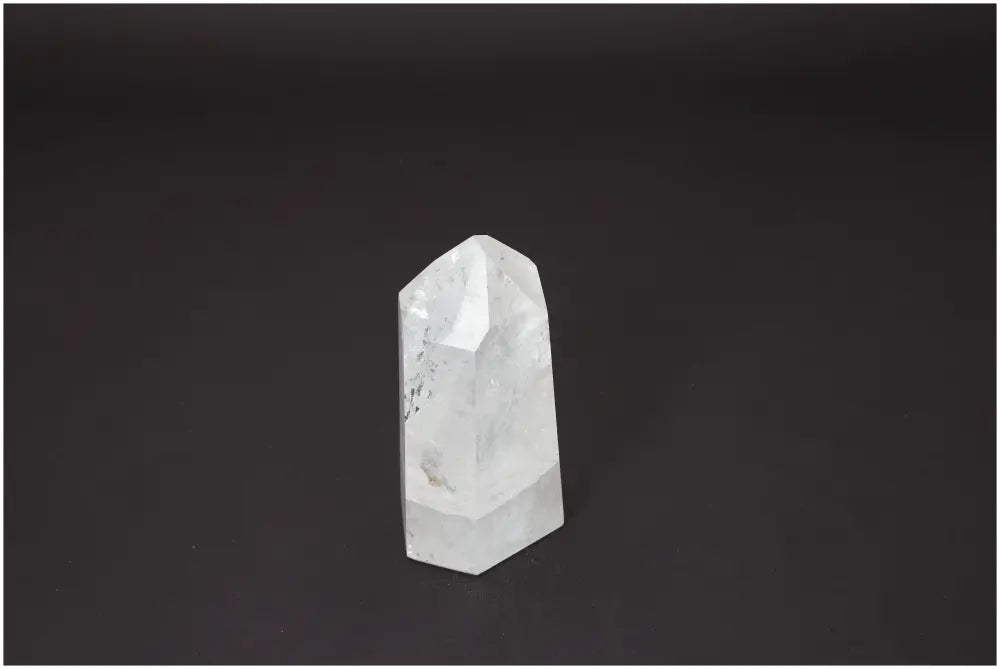 Lemurian Quartz Obelisk against a dark background, showcasing its unique properties and connection to chakras and zodiac signs.