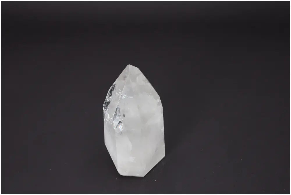 Lemurian Quartz Obelisk on dark background, enhances chakras and zodiac connections with unique energy properties.