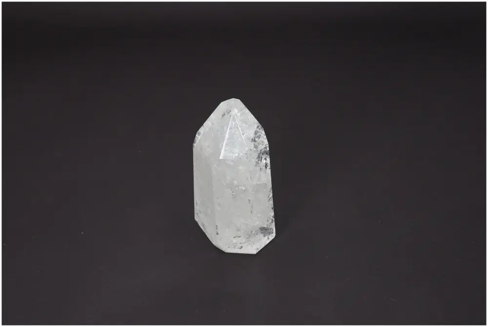 Lemurian Quartz Obelisk with unique energetic properties, beneficial for chakras and zodiac, on a dark background.
