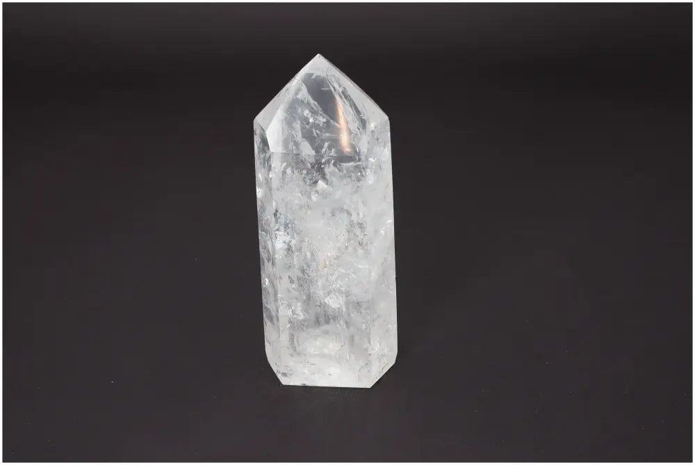 Lemurian Quartz Obelisk crystal on dark background, associated with chakras and zodiac signs for spiritual energy enhancement.