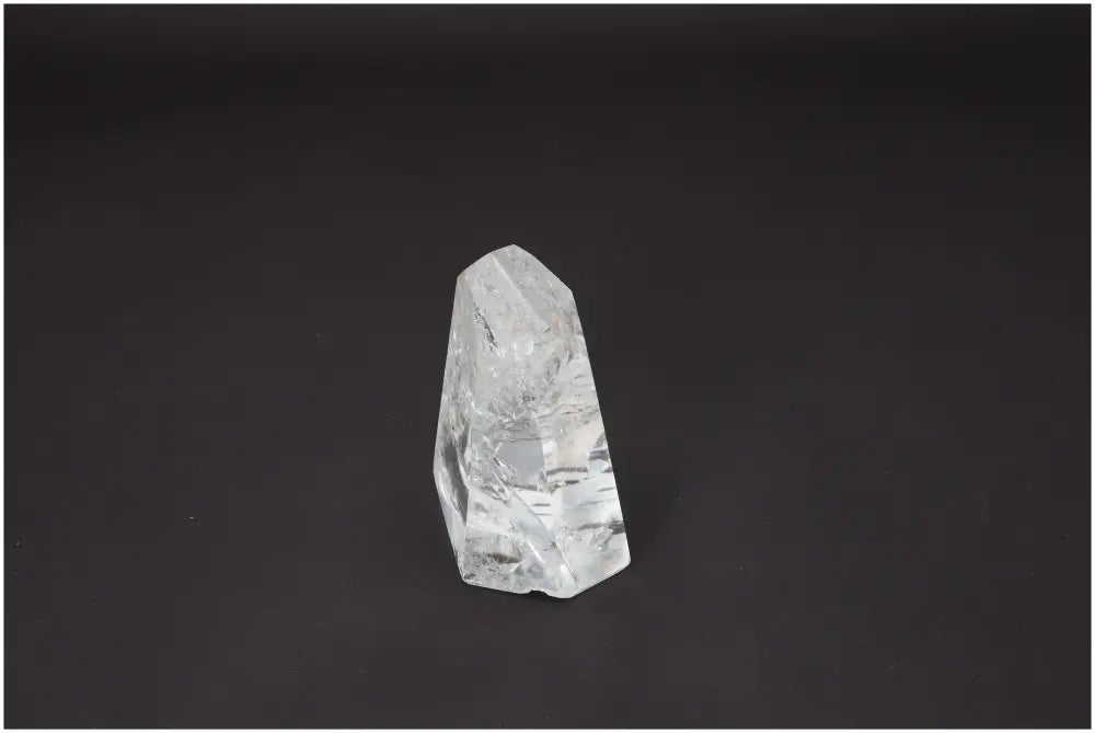 Lemurian Quartz Obelisk against a dark background, showcasing its clarity and spiritual properties for chakras and zodiac alignment.