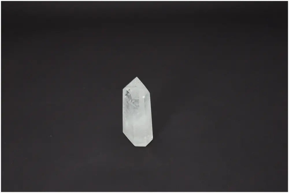Lemurian Quartz Obelisk on dark background; versatile quartz with unique spiritual properties, supports chakras and zodiac signs energetically.