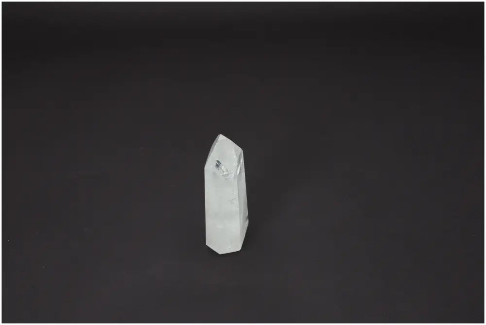 Lemurian Quartz Obelisk against dark background, highlighting its spiritual and energetic properties for chakra alignment.