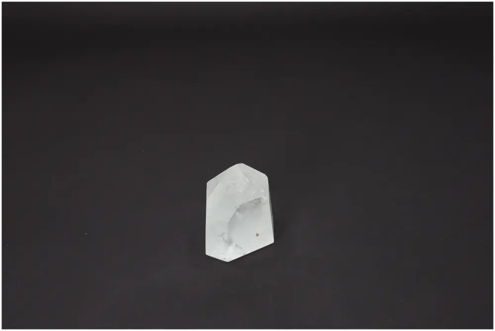 Lemurian Quartz Obelisk against a dark background, highlighting its clarity and unique crystal structure.