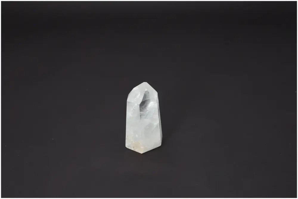 Lemurian Quartz Obelisk on black background, showcasing its unique crystal structure and spiritual properties for chakra alignment.