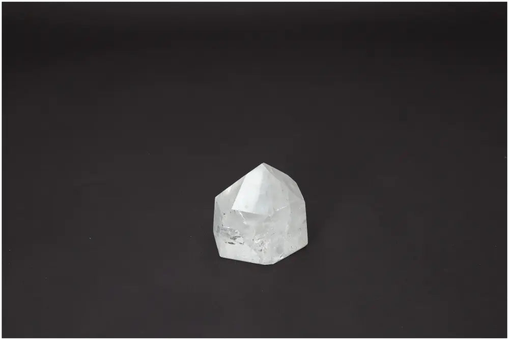 Polished Lemurian Quartz Obelisk on dark background, featuring unique properties for chakra alignment and spiritual enhancement.