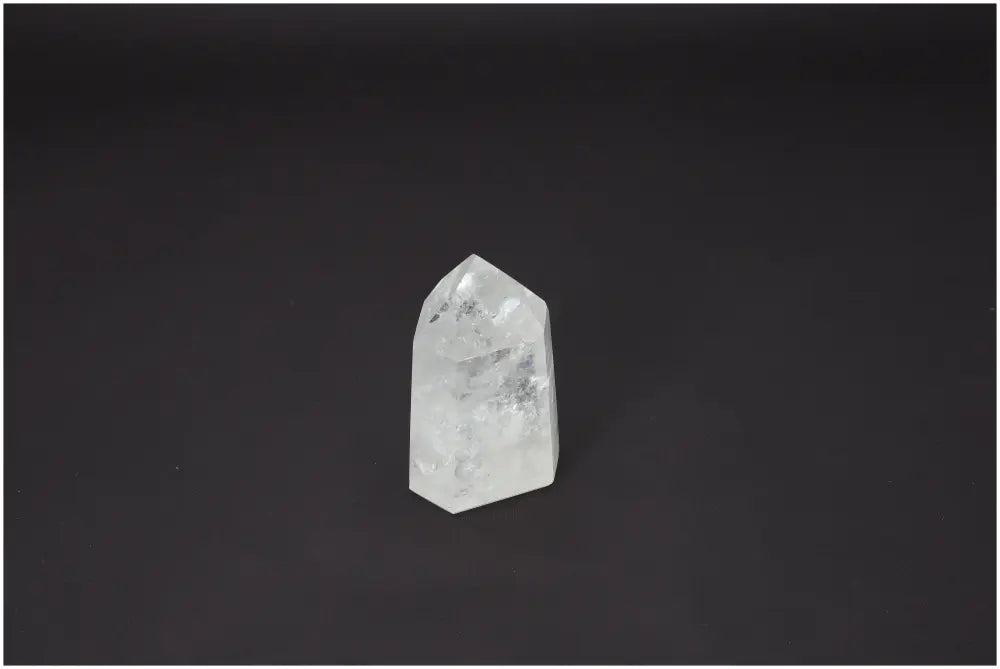Lemurian Quartz Obelisk crystal on dark background, showcasing its unique properties and spiritual benefits for chakras and zodiac signs.