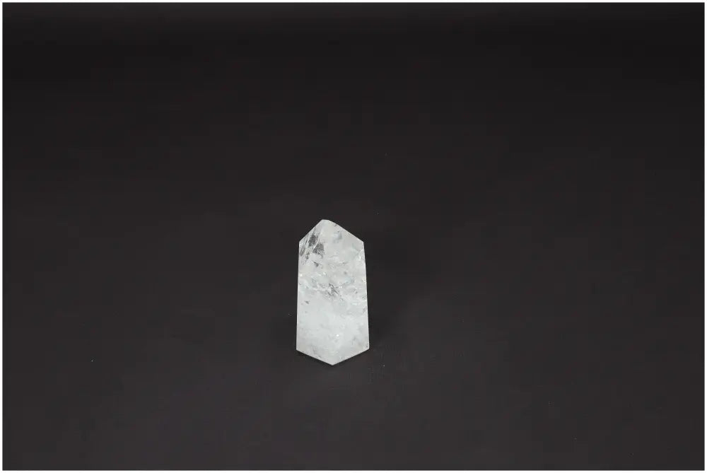 Lemurian Quartz Obelisk with unique energetic properties enhancing chakras, displayed on a dark background.