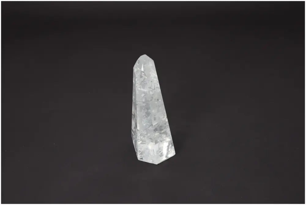 Elegant Lemurian Quartz Obelisk against black background, known for its spiritual and energetic properties, linked to chakras and zodiac signs.