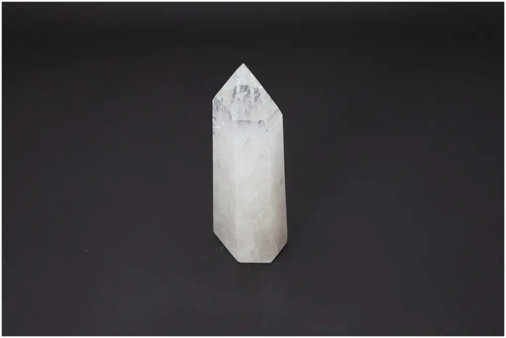 Clear Lemurian Quartz Obelisk on black background, showcasing unique properties that enhance spiritual energy and chakra alignment.