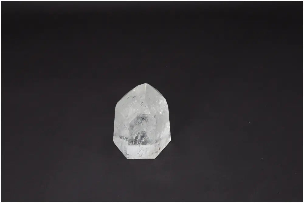 Lemurian Quartz Obelisk resting on a dark surface, showcasing its unique crystal structure and energetic properties.