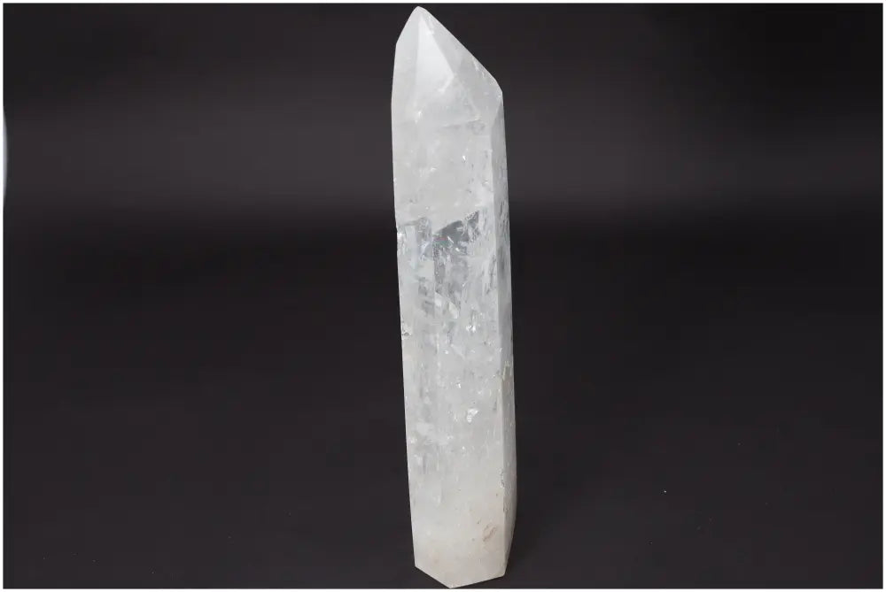 Lemurian Quartz obelisk; clear quartz crystal known as 'Master Healer' for clarity and balance on a dark background.