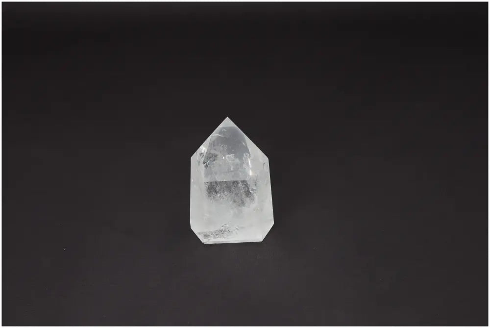 Clear Lemurian Quartz Obelisk on a dark background, known for enhancing clarity, balance, and energy healing.