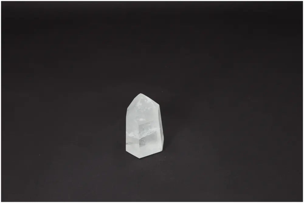Lemurian Quartz Obelisk on black background, a hand-selected clear crystal known for clarity and energy amplification.
