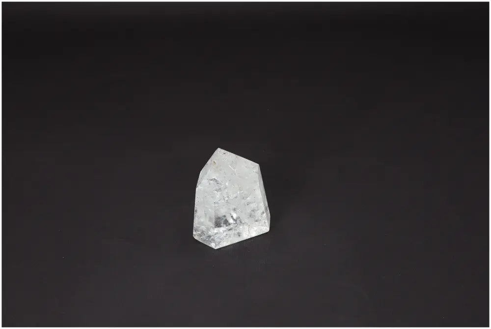 Clear Lemurian Quartz Obelisk on black background, enhancing energy and balance for personal growth and healing.