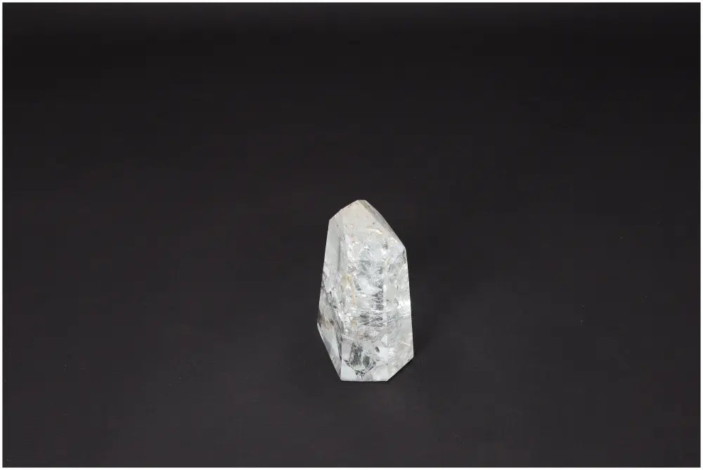 Lemurian Quartz Obelisk on dark background, clear crystal for clarity and balance, ethically sourced and naturally formed.