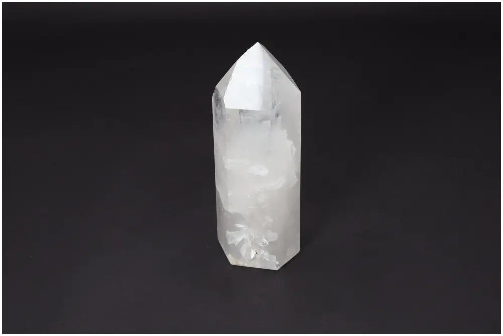 Clear Lemurian Quartz obelisk on black background, known as a "Master Healer" for energy amplification, clarity, and personal growth.