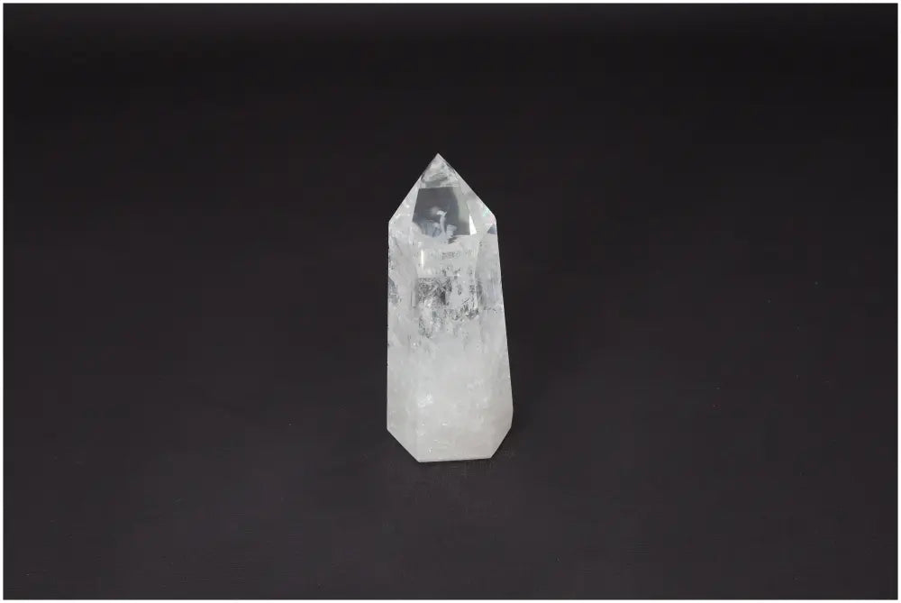 Lemurian Quartz Obelisk on black background, a clear healing crystal for clarity and balance, ethically sourced and naturally formed.