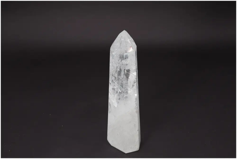 Lemurian Clear Quartz Obelisk on black background, crystal for clarity and personal growth.