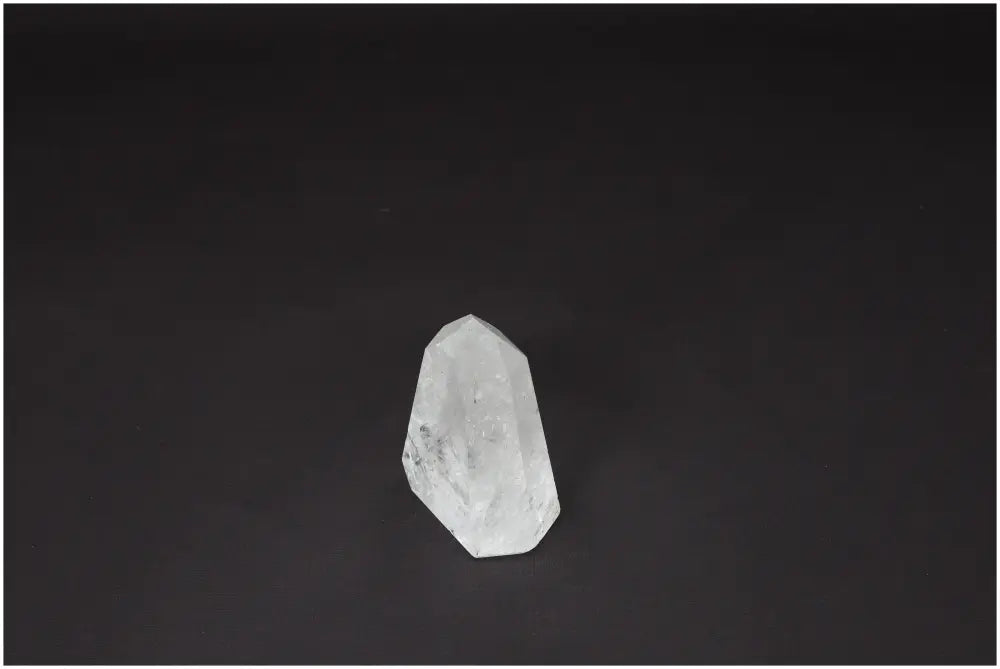 Lemurian Clear Quartz obelisk on a dark background, known for clarity, balance, and personal growth. Master Healer crystal for energy.