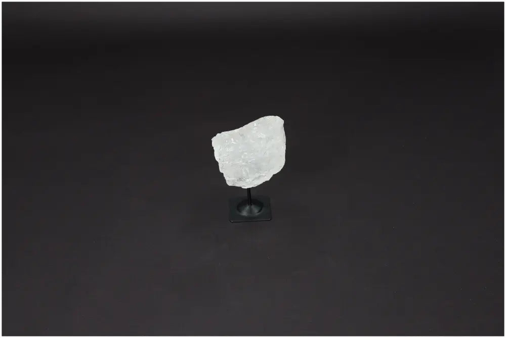 Lemurian Quartz crystal on metal stand against dark background, known as "Master Healer" to enhance clarity, balance, and growth.