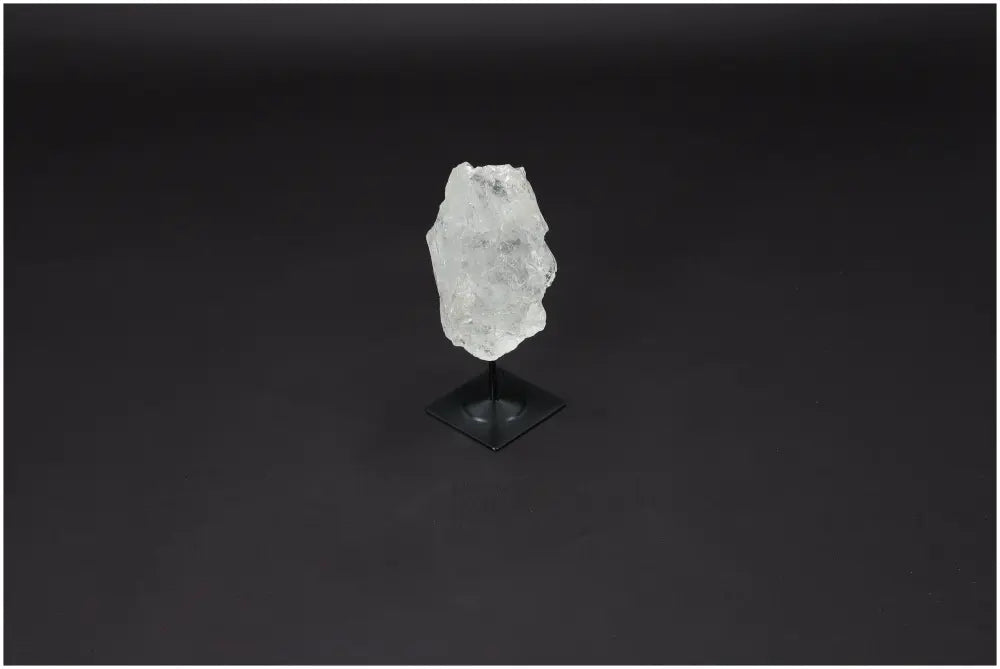 Lemurian Quartz crystal on a metal stand against a dark background, showcasing its natural clarity and healing properties.