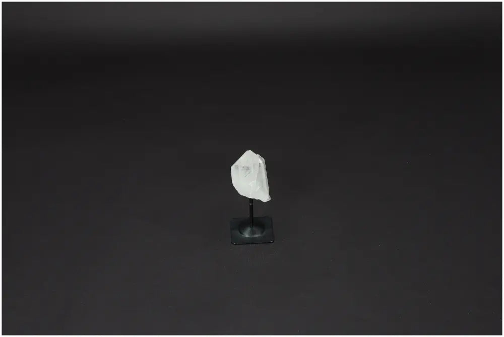 Lemurian Quartz crystal on a sleek metal stand against a dark background, ideal for promoting clarity and balance.