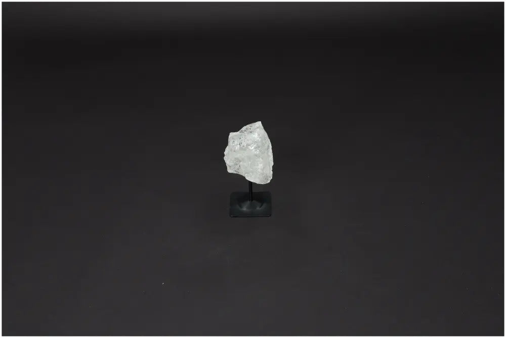 Lemurian Quartz crystal on metal stand, known as 'Master Healer' for clarity and balance, against a dark background.