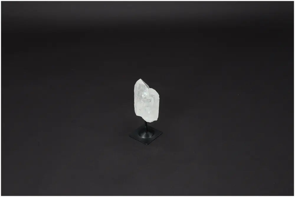 Lemurian Quartz crystal on a metal stand against a dark background, showcasing its clarity and natural formation.