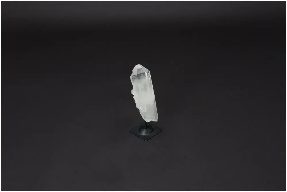 Lemurian Quartz crystal on a metal stand showcasing its natural clarity and healing properties against a dark background.