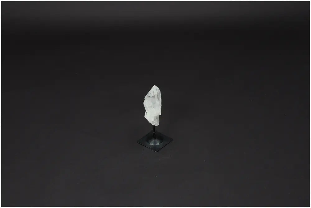 Clear Lemurian Quartz crystal on a sleek metal stand, ethically sourced, amplifies energy and intentions, promotes clarity and healing.