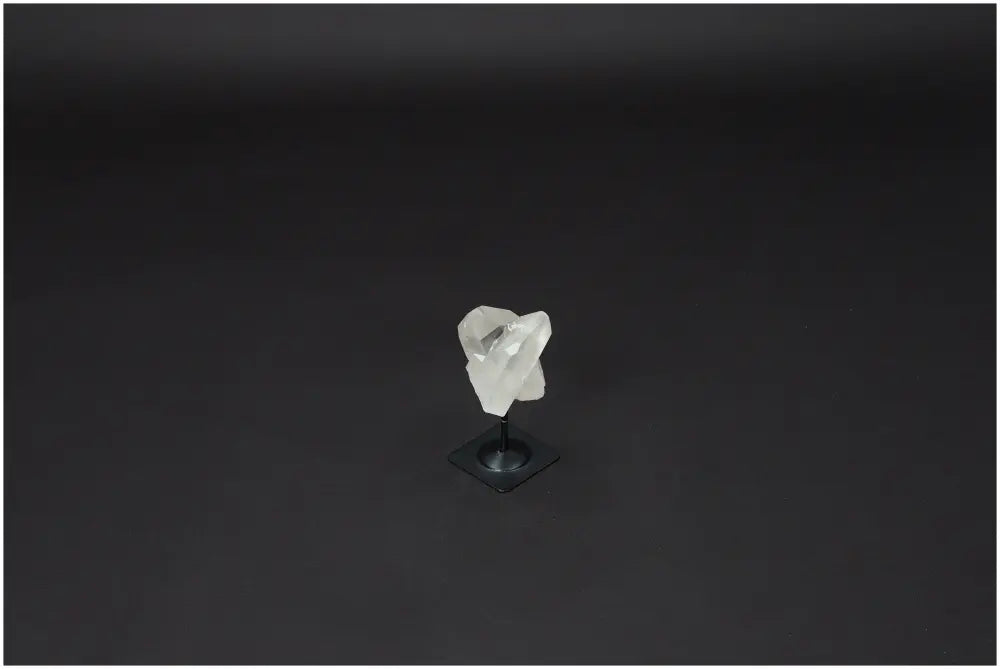 Lemurian Quartz on a metal stand against a dark background, highlighting its clear, purifying properties.