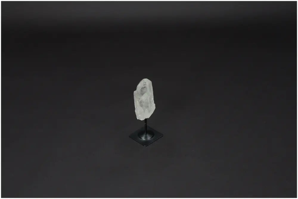 Lemurian Quartz gemstone on a metal stand against a dark background; ideal for energy purification and negative vibration neutralization.