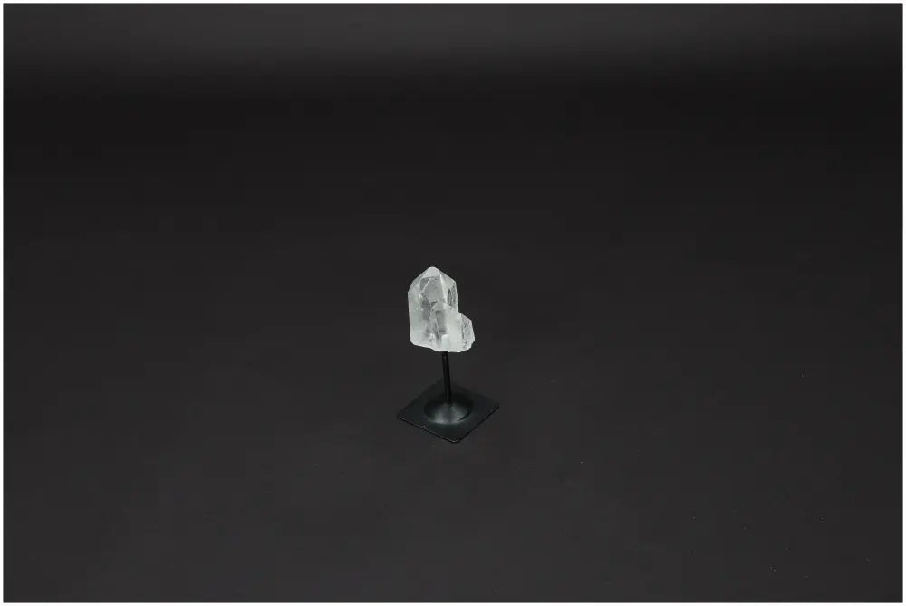 Lemurian Quartz crystal on metal stand against a dark background, known for purifying and harmonizing energy. Perfect for home or office decor.