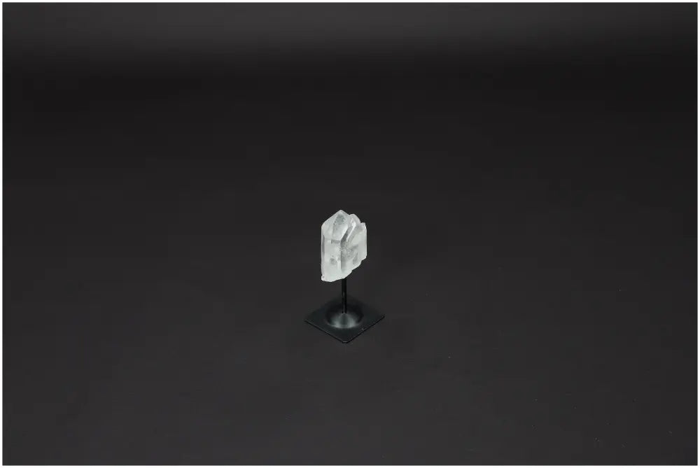 Lemurian Clear Quartz on a sleek metal stand against a dark background, ideal for purification and harmonizing energy.