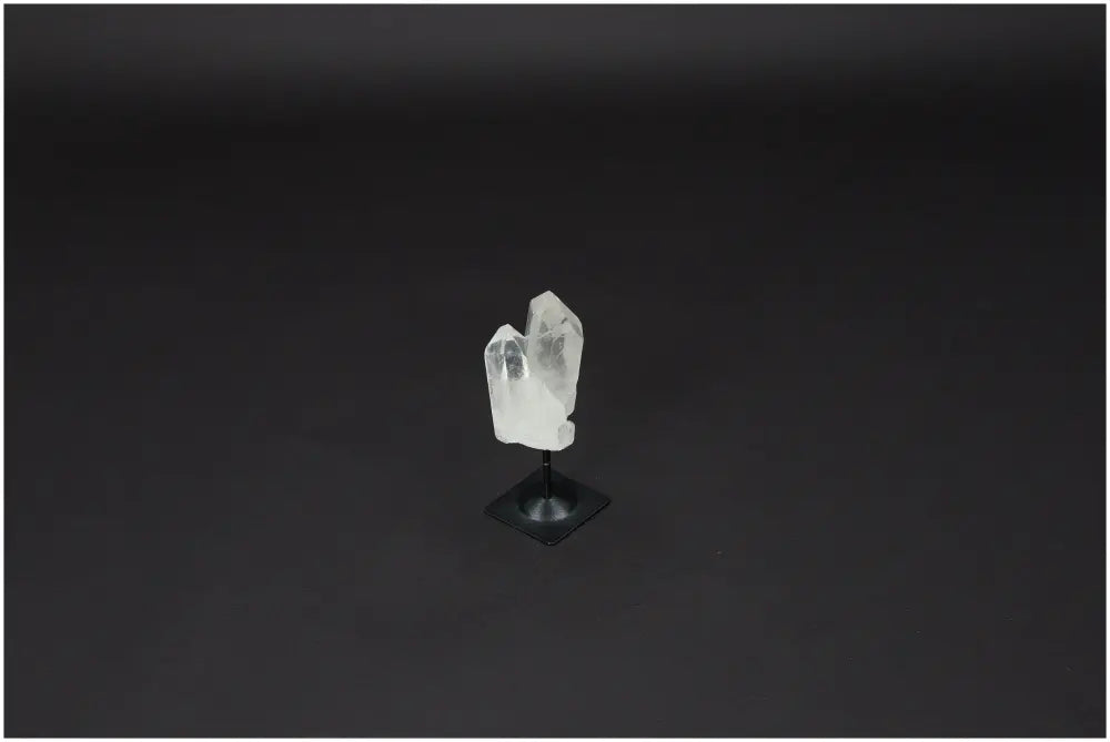 Lemurian Quartz on metal stand, showcasing clear quartz known for energy purification and harmonizing properties against a dark background.
