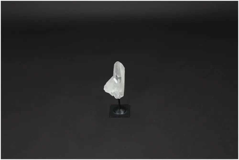 Lemurian Clear Quartz on metal stand against dark background, ideal for purification and harmonizing energy. Absorbs negative vibrations.