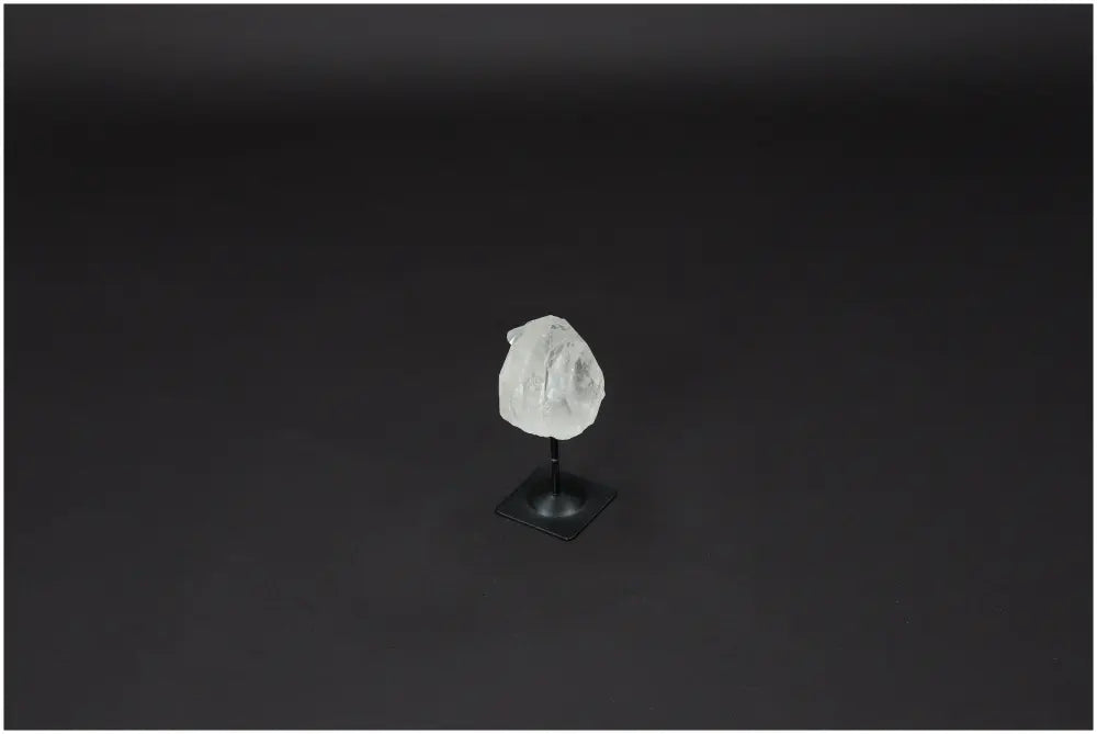 Lemurian Quartz on metal stand against a dark background, exemplifying its purification and harmonizing qualities.