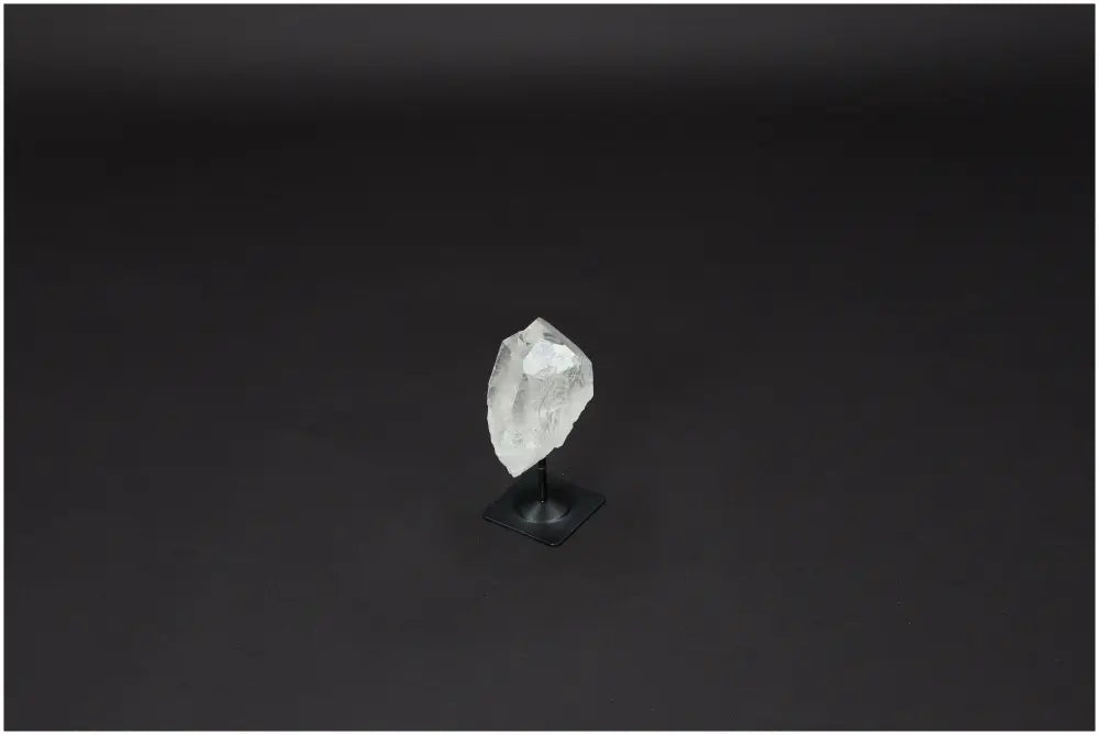Lemurian Quartz on metal stand against black background, showcasing its clarity and purification qualities for harmonizing energy and space.