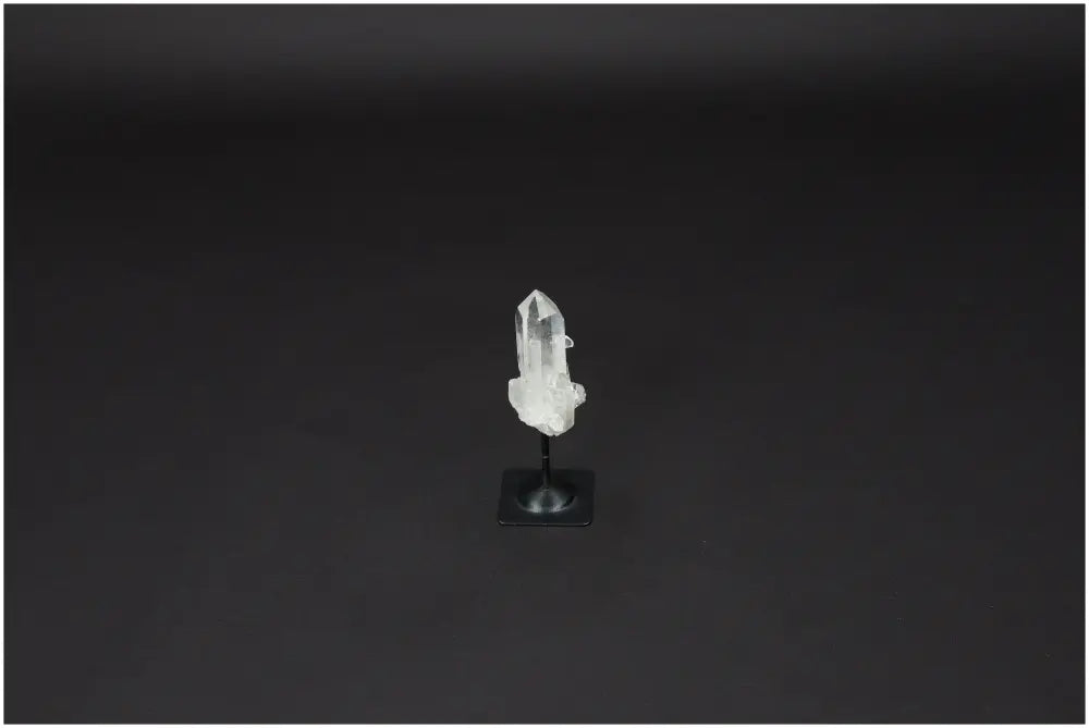 Lemurian Quartz with powerful purification properties on a sleek metal stand against a dark background.